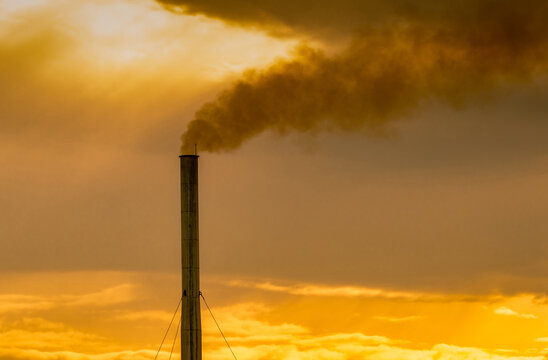 Air pollution from factory. Smoke from chimney of industrial pipe on sunset sky. Global warming problem concept. Bad air quality. Air pollutant emission factors. Air contamination. PM 2.5 dust.