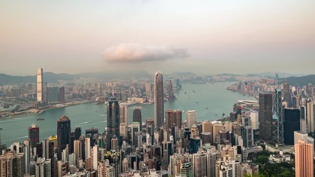 Time-lapse of Hong Kong skyline from Victoria Peak, transitioning from sunny afternoon to glowing blue hour.