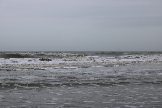 Atlantic Ocean surf at Folly Beach, South Carolina on a gray day in March under heavy clouds and cool temperatures. 