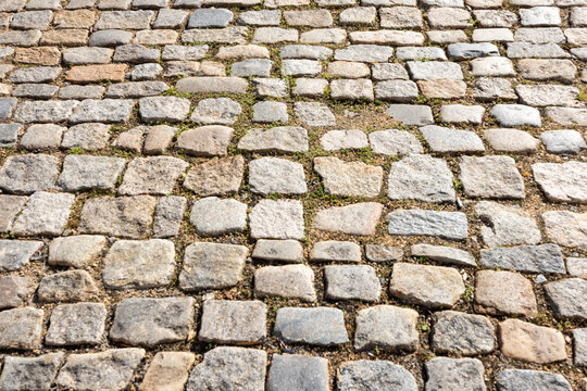 Weathered, uneven cobblestone street in historic Shockoe Bottom, Richmond, Virginia, taken during golden hour. 