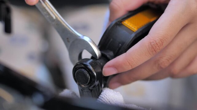 Close-up of a hands using a wrench to adjust a bicycle component during maintenance and repair