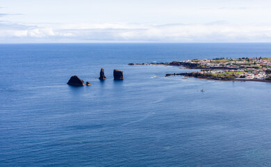 Fototapeta premium Mosteiros, San Miguel Island, Azores. Rock formations along the Atlantic coastline. Small coastal town in the background. Clear blue ocean waters.