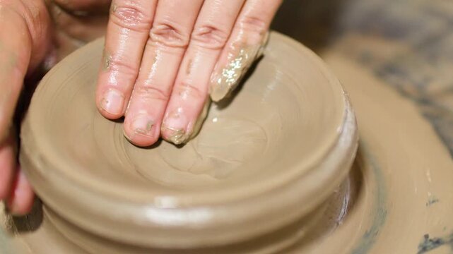 Artisan Hands Shaping Wet Clay on a Spinning Pottery Wheel