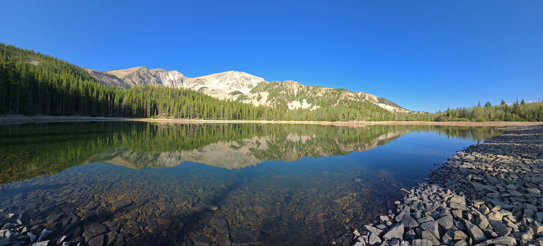Panorama of Mt Sopris reflected in calm water of second Thomas Lake in White River National Forest near Carbondale, Colorado on sunny summer morning.