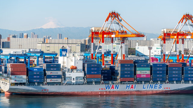 Container ship of Wan Hai Lines Taiwanese logistic company at port dock with cranes and Mount Fuji in Tokyo Japan