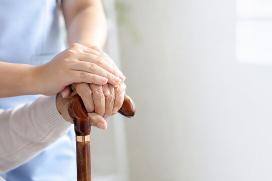 Hand support elder care aging population care help hand holding walking cane senior assistance comfort compassion