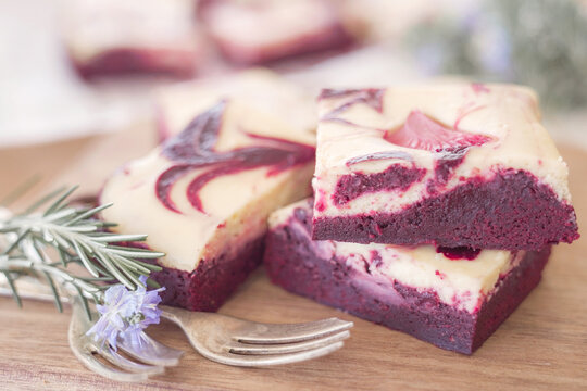 red velvet brownie, cheesecake swirl, dessert, sweet, chocolate, gourmet, homemade delicious red velvet cheesecake brownies with elegant cream cheese swirl pattern on a rustic board.
