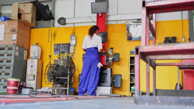 Female worker in blue overalls engaged in a vibrant industrial setting surrounded by various tools and equipment