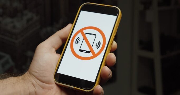 Close-up of a smartphone displaying a sound prohibited symbol. Ideal for silent mode, muted devices, quiet zones, and no sound concepts.