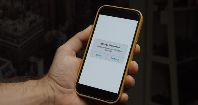 Close-up of a smartphone displaying a storage almost full warning. Ideal for low storage, device management, digital organization, and technology concepts.