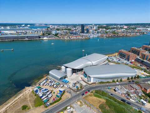 Aerial view of the Woolston Water Treatment Plant with modern silver-roofed buildings, boat storage, and the River Itchen with the city skyline, Southampton, England, United Kingdom.