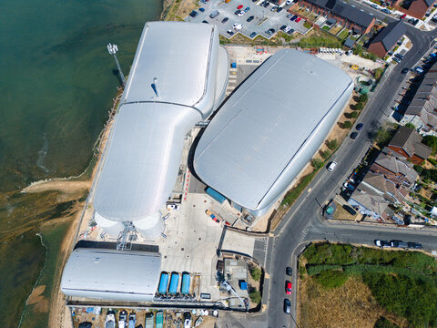 Aerial view of the Woolston Water Treatment Plant featuring large curved metallic roofs situated along the waterfront in Southampton, England, United Kingdom.