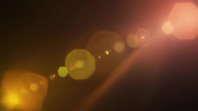 Warm golden sunset light leak flows across dark space with honey gold, amber and soft peach gradients, cinematic sun glow, optical bloom and atmospheric diffusion for premium video overlays.