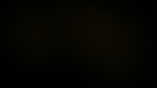 Glowing golden light bokeh background transitions with soft warm radiance moving across the dark frame in this professional creative motion graphic stock video footage animation designed for elegant c