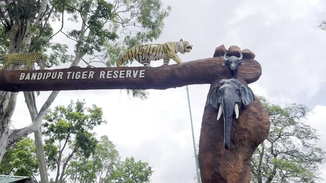 Bandipur Tiger Reserve entrance arch in Karnataka India with tiger sculpture, forest trees and tribal wildlife statue, showcasing famous national park gateway, safari tourism and conservation landmark
