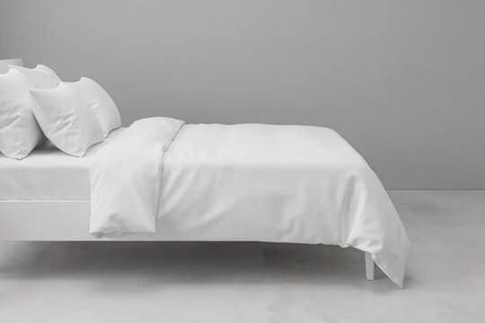 A comfortable bed with white linens. Ideal for home interior design.