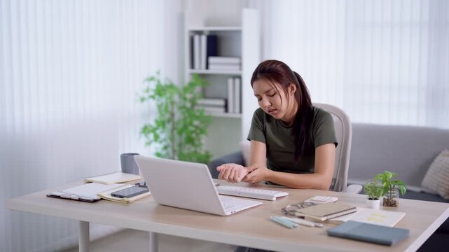 Young Asian woman experiencing stress and frustration while working on laptop in bright home office