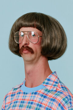 people of ai, yearbook photo of a person with dark-brown gray bowl bob, neutral expression with mustache and large glasses, cyan-pink plaid shirt, photorealistic.png