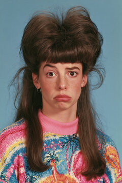 people of ai, yearbook photo of a person with tall two-tone brown bouffant with long straight sides, worried sad pout, multicolor patterned sweater, photorealistic.png