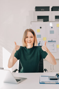 Concept of business working, Businesswoman sitting while writing and checking business analytic document  report  and holding tablet with computer pc, smartphone on desk in her workstation.
