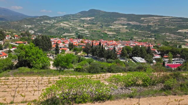 Aerial view near Omodos in Cyprus. Countryside roads, vineyards, village rooftops and green hills create a scenic rural travel view.