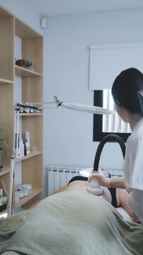 Female Aesthetician Delivering Targeted Radiofrequency Body Contouring in Minimalist Clinical Room