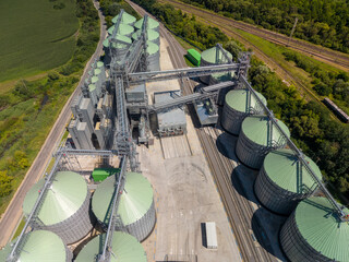 Straight down view of modern agroindustrial facility showing metallic grain storage silos connected by complex transport systems. © Pasha