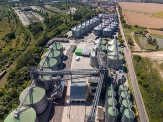 Elevated viewpoint of extensive agroindustrial storage facility with modern metallic silos and transport conveyor systems. © Pasha