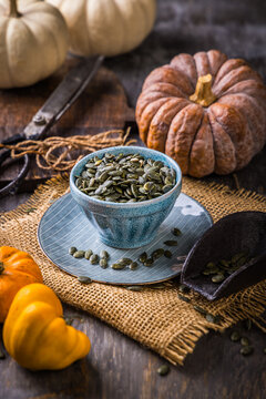 Pumpkin seeds and flour powder displayed with a vintage coffee grinder on rustic wood