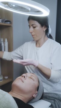 Aesthetic Professional Delivering Gentle Facial Massage and Skincare Treatment in Bright Clinical Space