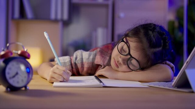 Tired young girl in glasses resting head on arm while holding pencil and struggling to study late at desk with clock