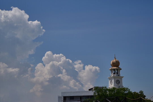 Victoria Memorial Clock Tower beneath towering tropical clouds in George Town Penang Malaysia
