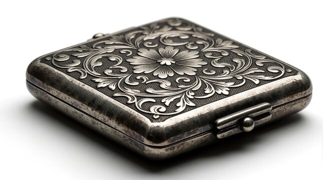 Antique silver cigarette case with ornate floral engraving on white background. Vintage metal box features intricate scrollwork pattern. Luxury pocket container represents classic craftsmanship