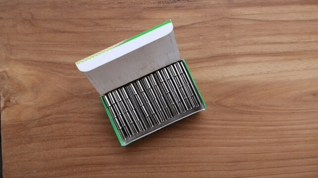 Top View of Steel Butt Hinges Packed Inside Open Cardboard Box on Wooden Table