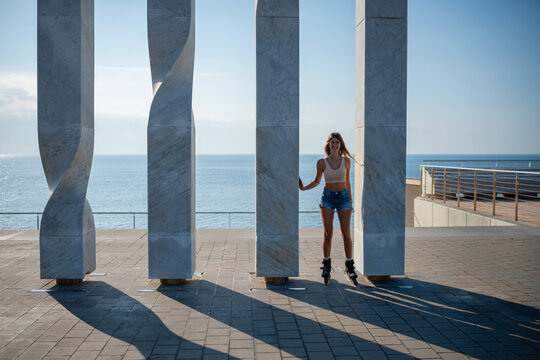 Young woman rollerblading between sculptures enjoying leisure
