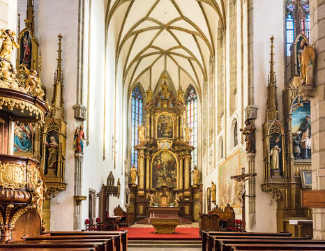 Interior of Gothic Church of St. Vitus with ornate main altar and vaulted ceiling in Cesky Krumlov, Czechia, UNESCO World Heritage Site