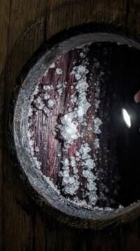 Macro View of Tartrate Wine Crystals Formed Inside an Aged Oak Barrel Illuminated by a Flashlight