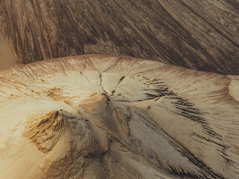 Aerial view of sand textures forming intricate patterns and ridges on a large pile of sand in Poland.