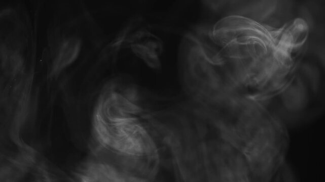 White puffy smoke against a black background