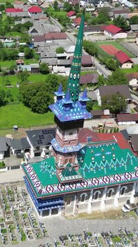 Aerial drone footage showcasing the Merry Cemetery in Sapanta, Romania, a unique open-air museum celebrated for its colorful carved gravestones