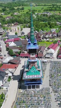 Aerial perspective of the Merry Cemetery, a unique open air museum in Sapanta, Romania. Colorful church and wooden crosses in a beautiful valley. With more than 800 colorful oak wood crosses