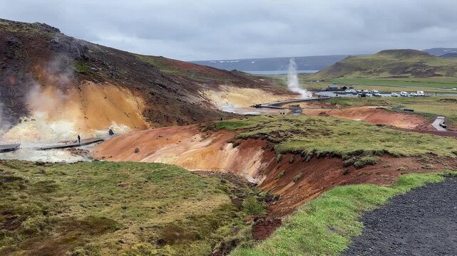 Stunning volcanic landscape of the Seltun Geothermal Area in Iceland, with steaming fumaroles, colorful mineral deposits, and a geyser