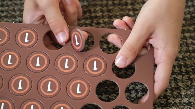 Child hands pressing out cardboard game tokens at home. Number one toy coins. Board game components, hobby activities, early development. High quality 4k footage.