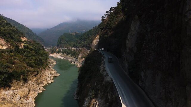 Aerial view following a truck in a river valley on Prithvi Highway, Nepal