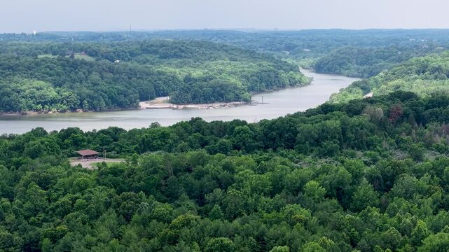 High aerial panorama of a winding river cutting through expansive forest and rolling rural countryside, Dillon Lake, Ohio