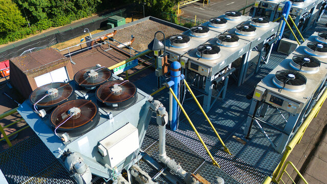 Aerial view of data center HVAC thermal management and cooling fans installed on a rooftop with metal grating and industrial piping in Andover, England, United Kingdom.