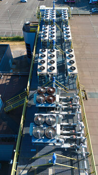 Aerial view of data center HVAC thermal management and cooling fans installed on a rooftop with industrial piping and metal grating in Andover, England, United Kingdom.