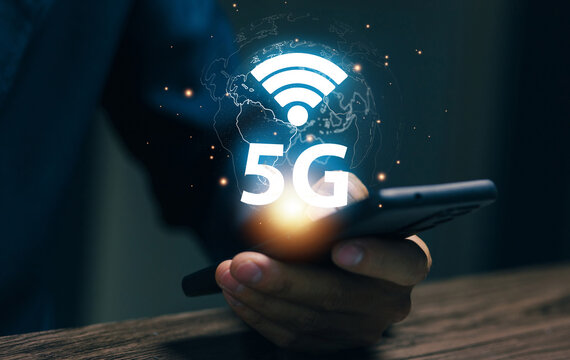 Businesswoman using smartphone with 5G wireless network connection, mobile communication, global internet technology, fast connectivity and digital transformation for business.