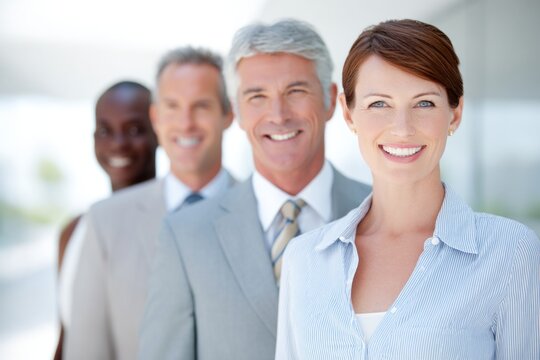 Professional group of diverse business people smiling together in a bright modern office space