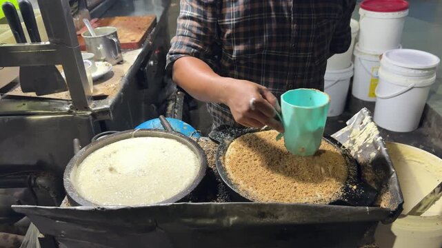 Motion footage of street food vendor preparing traditional Apam Balik sweet pancakes on outdoor griddles, 4k video clip.